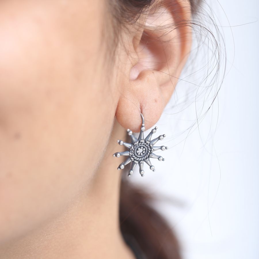 a close up of a person wearing a pair of earrings
