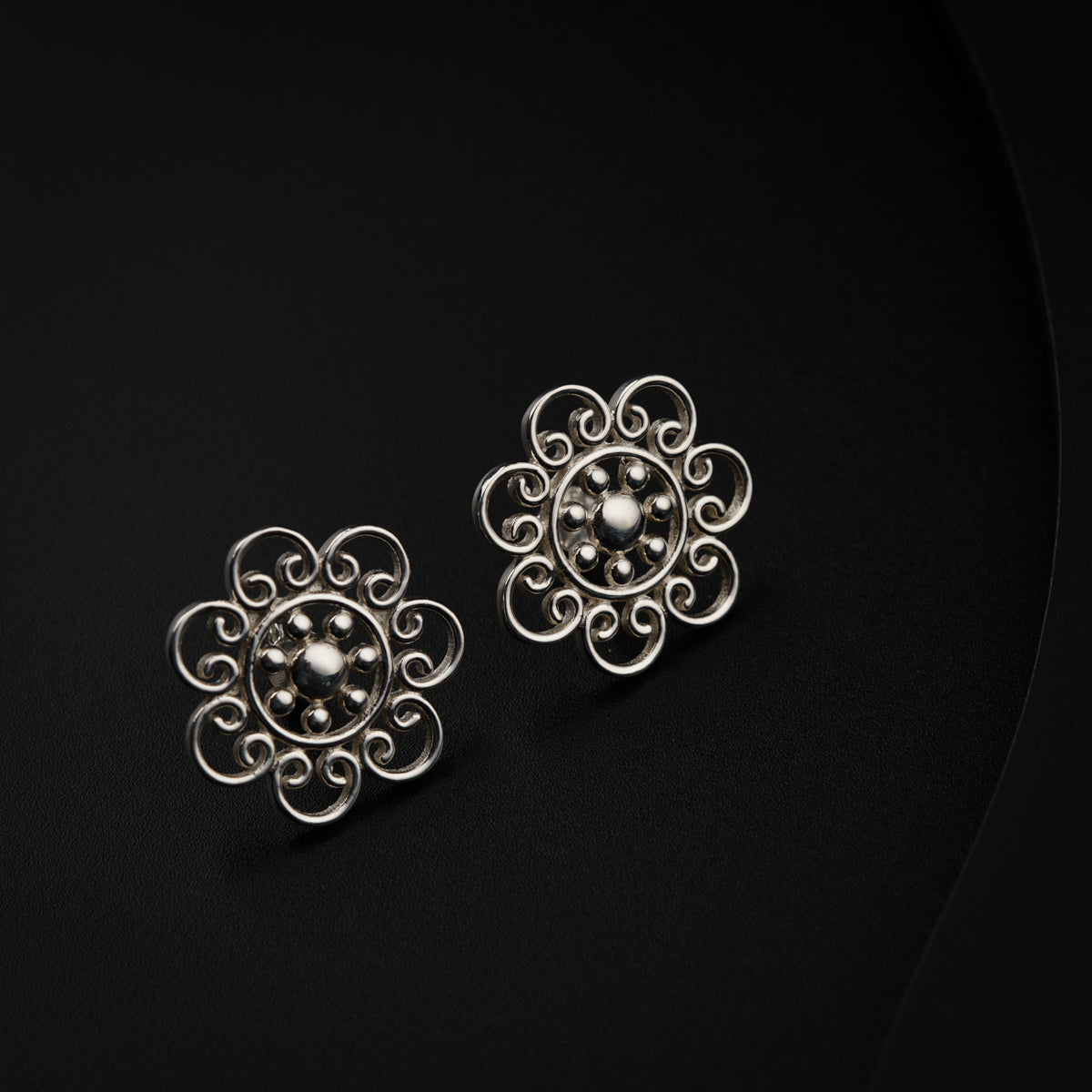 a pair of earrings on a black surface