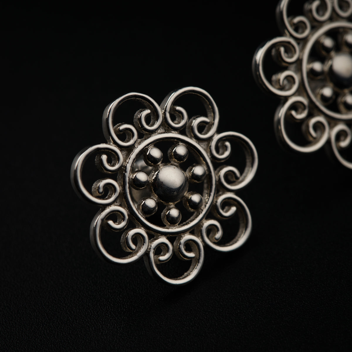 a close up of a pair of earrings on a black surface