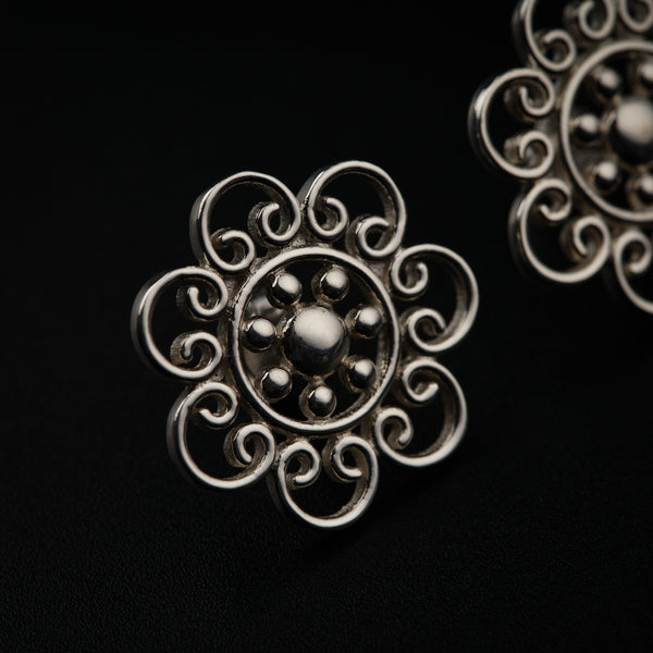a close up of a pair of earrings on a black surface