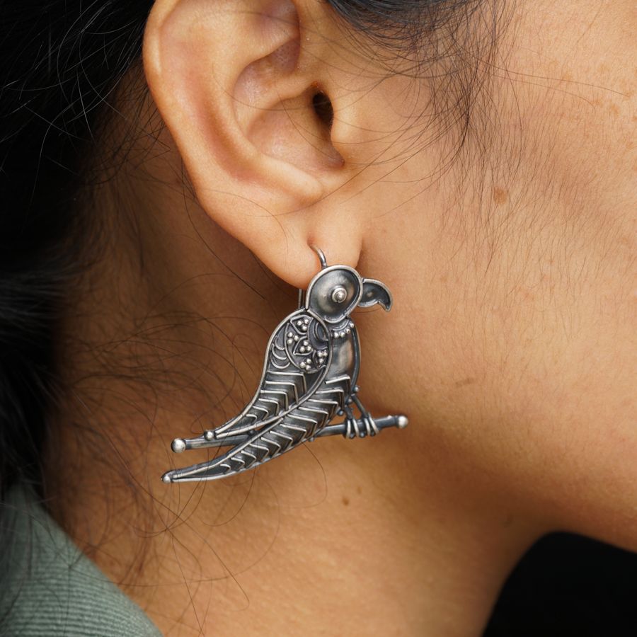 a close up of a person wearing a pair of earrings