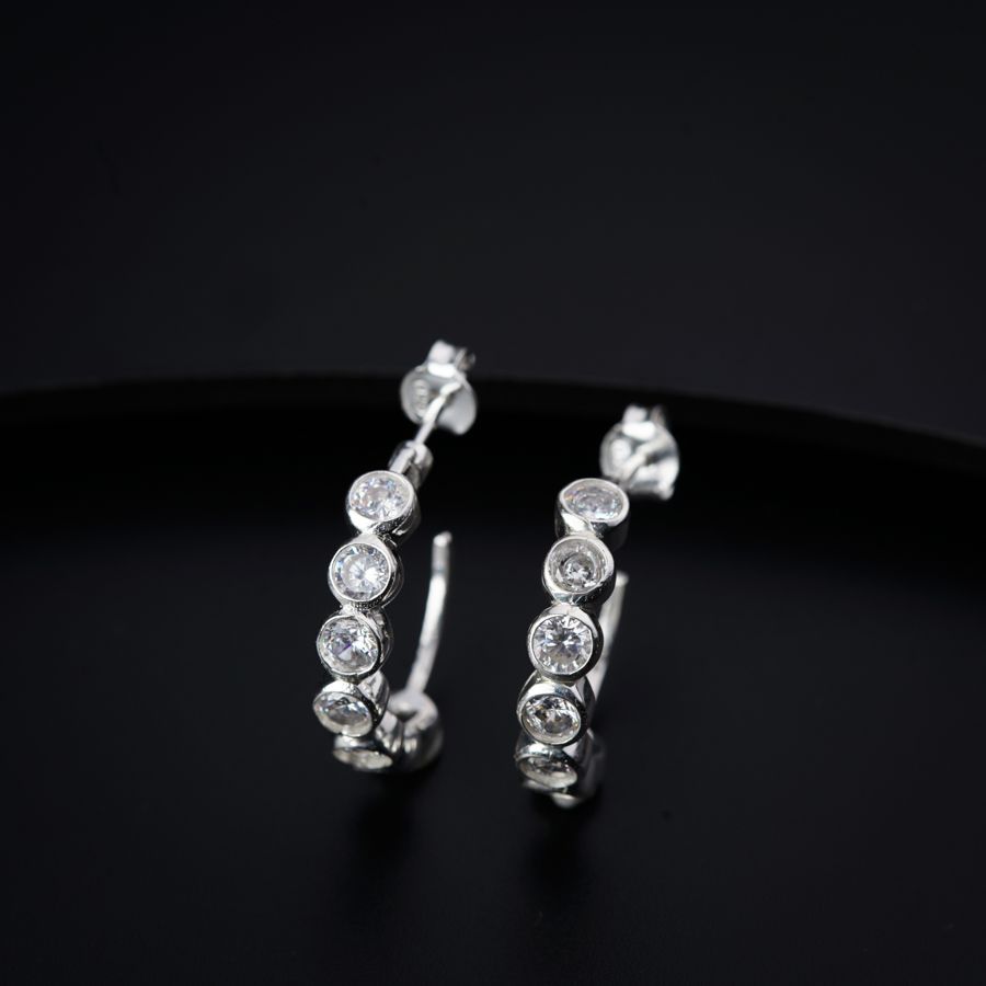 a pair of diamond hoop earrings on a black surface