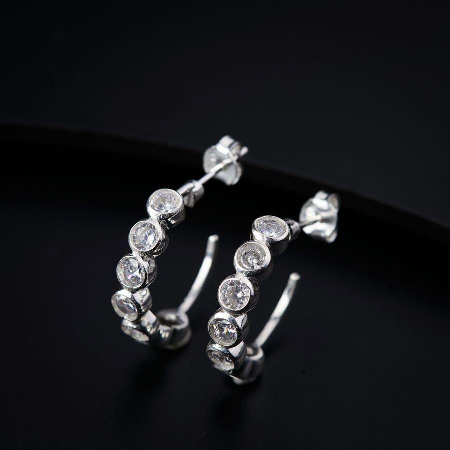 a pair of diamond hoop earrings on a black surface