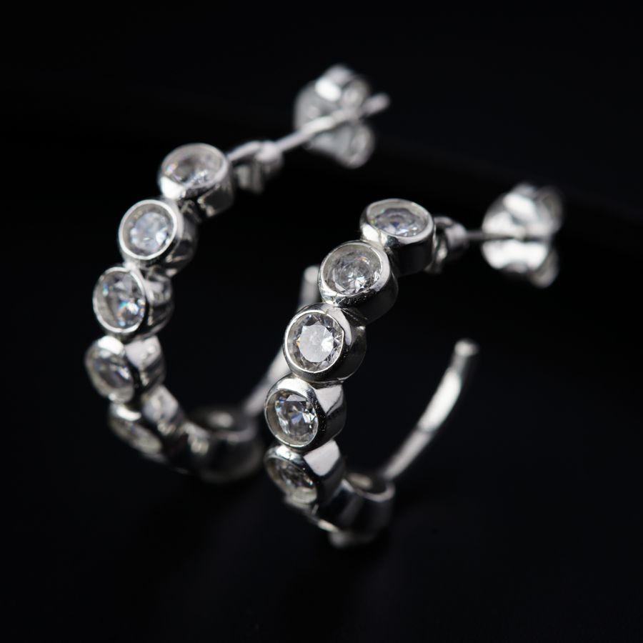 a pair of diamond hoop earrings on a black background