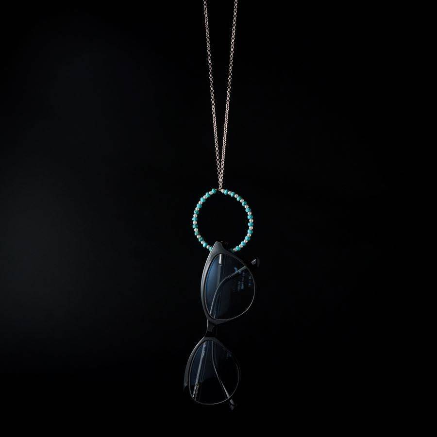 a blue beaded necklace with a black cat on it