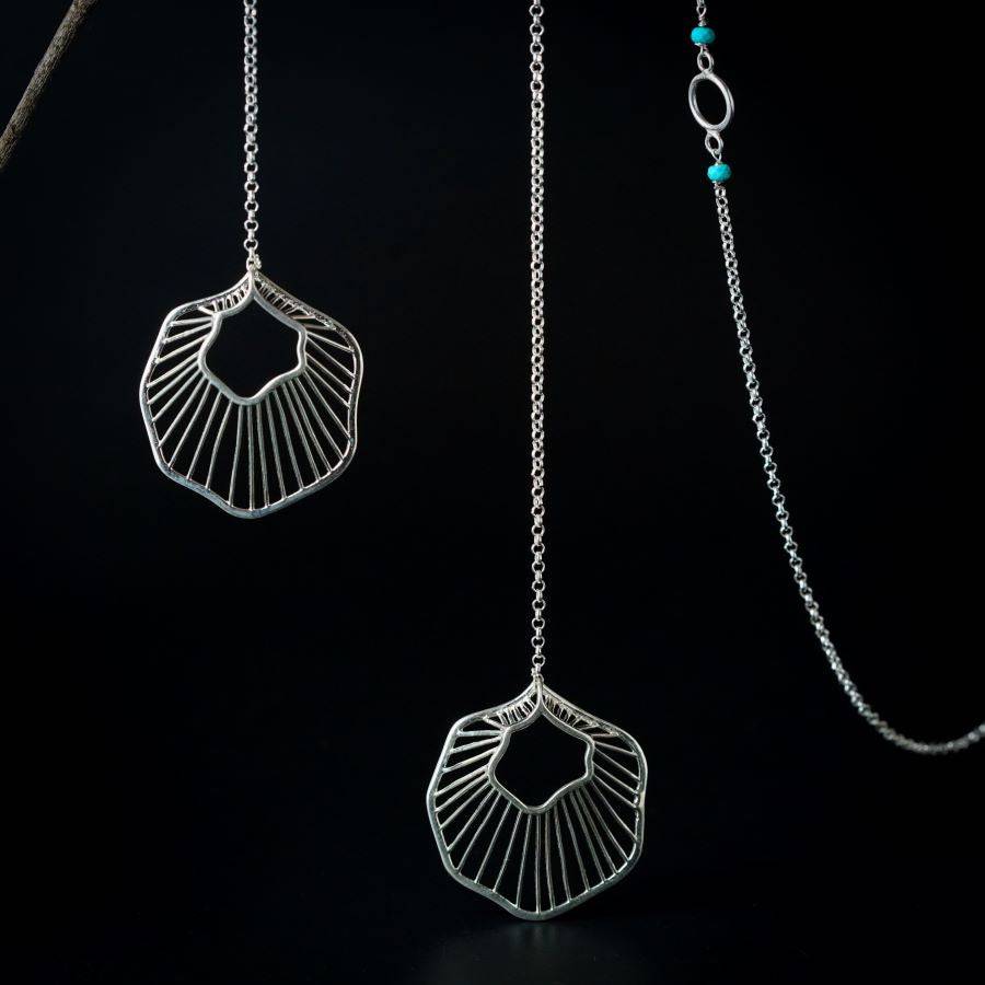 a pair of silver earrings hanging from chains
