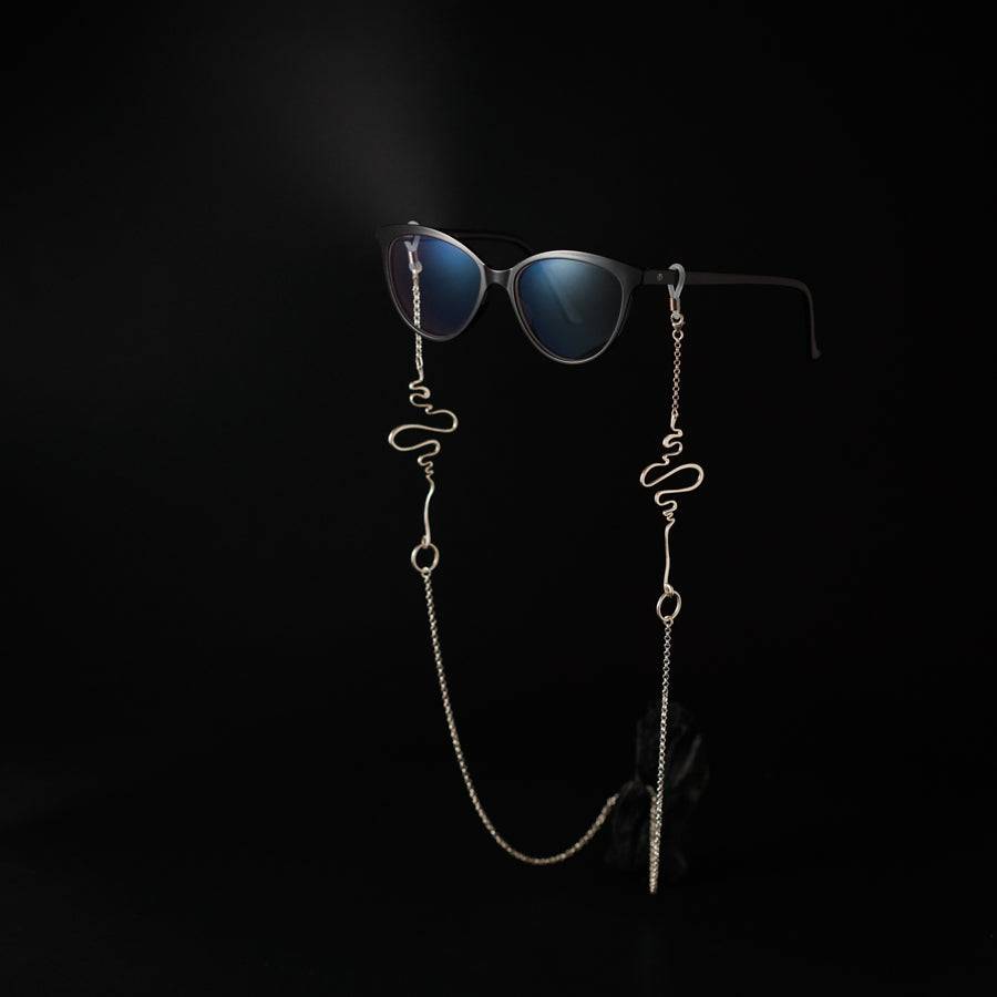 a pair of sunglasses and a chain on a black background