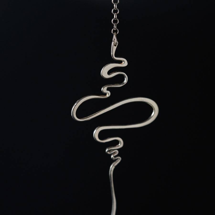 a silver necklace with a snake on it