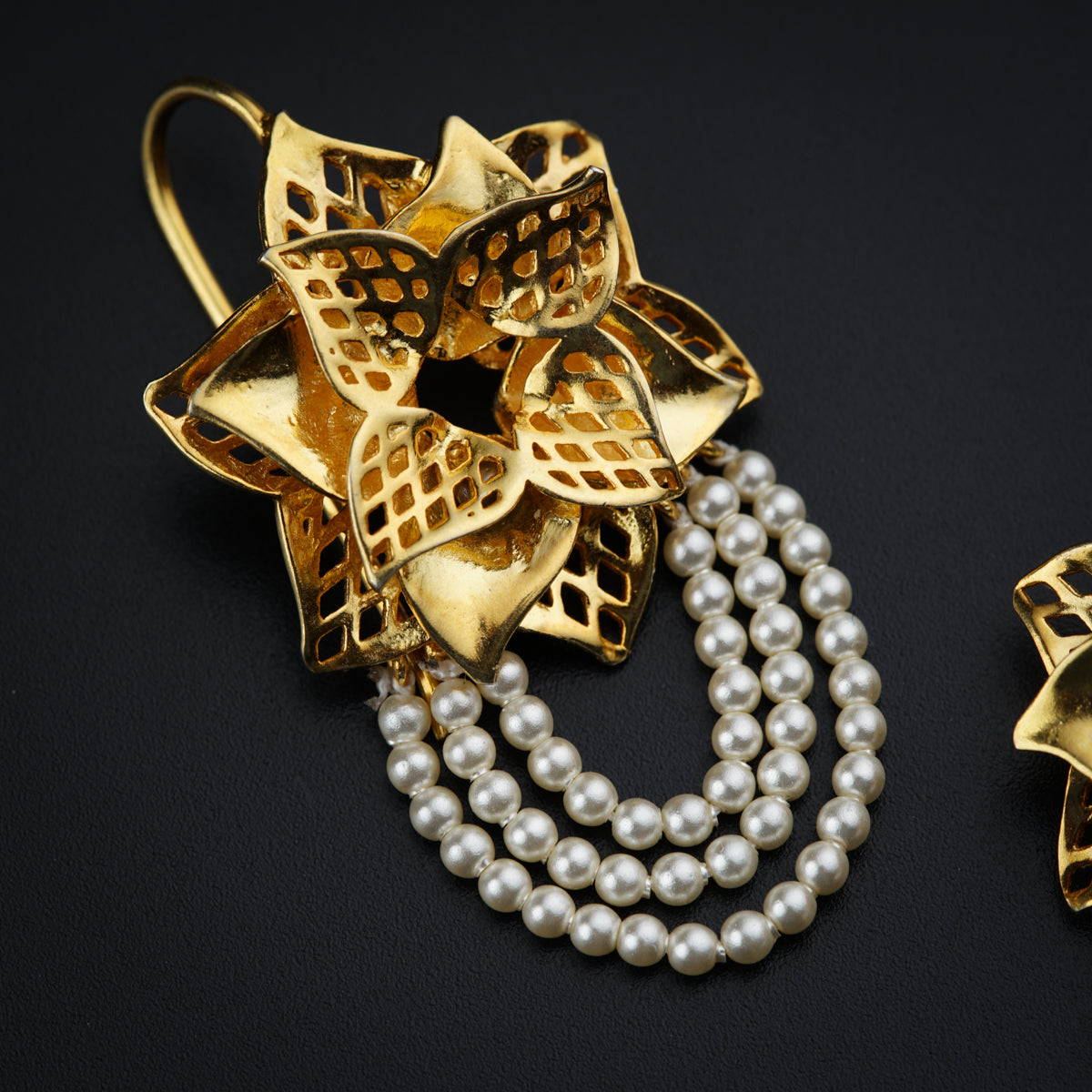 a close up of a brooch with pearls