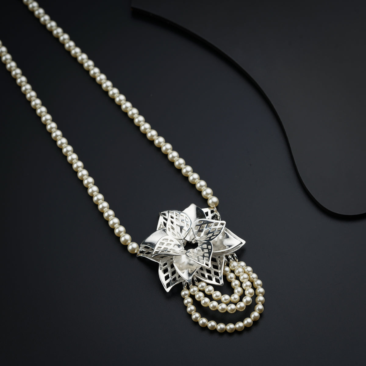a pearl necklace with a flower on it