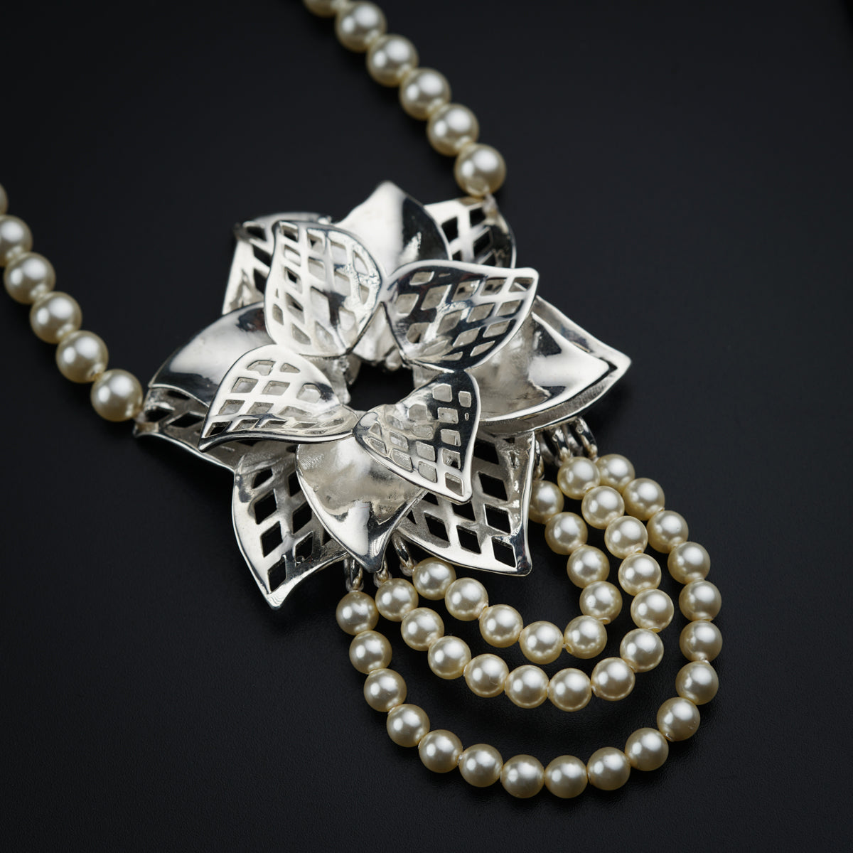 a close up of a necklace with pearls