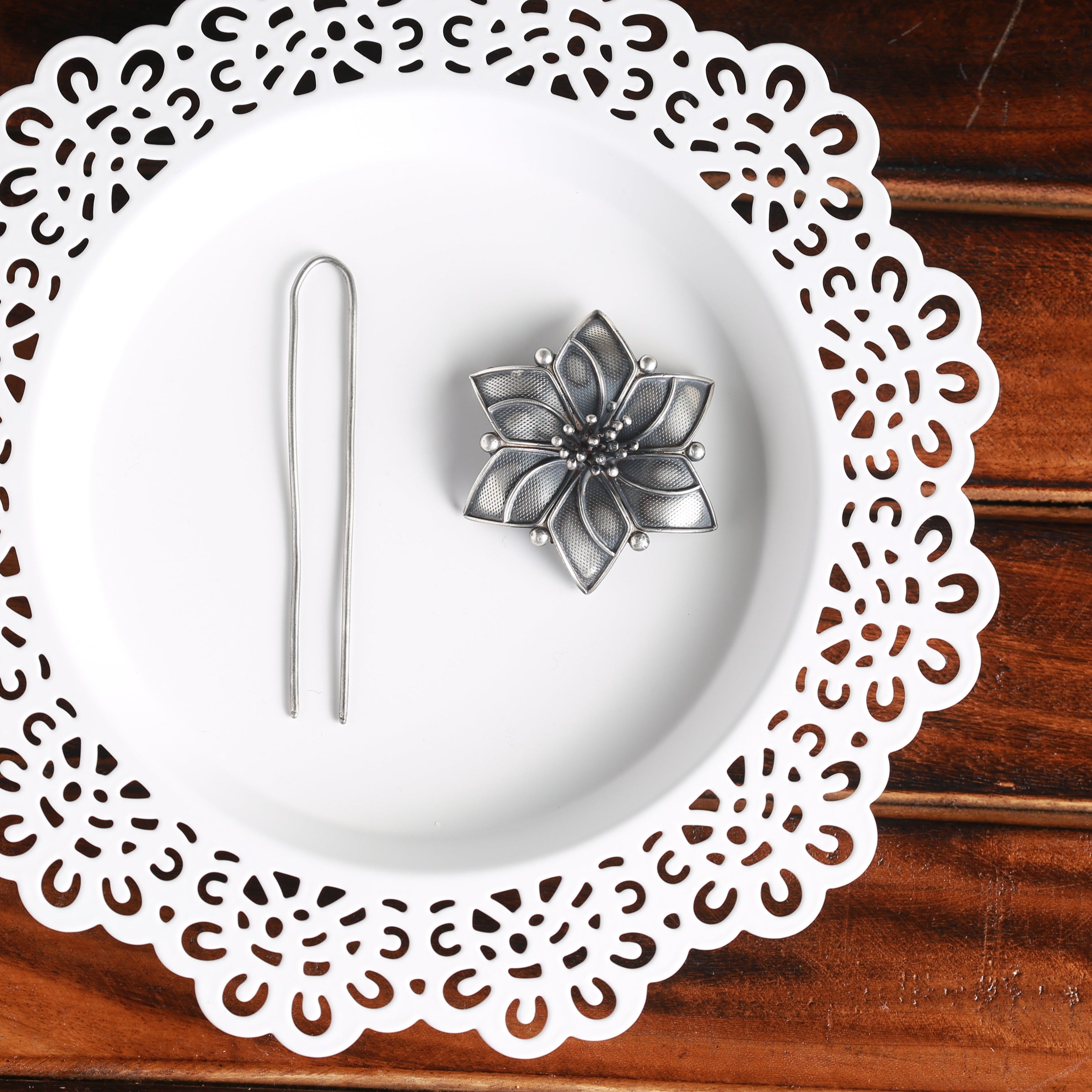 a white plate topped with a flower next to a pair of scissors