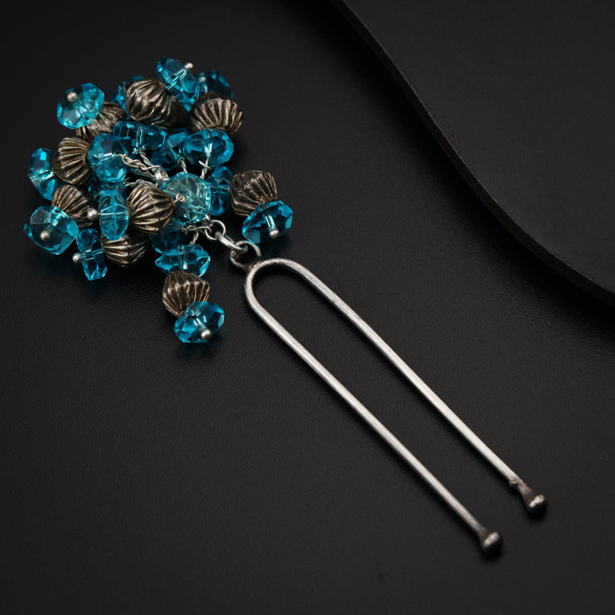 a bunch of blue beads are on a black surface