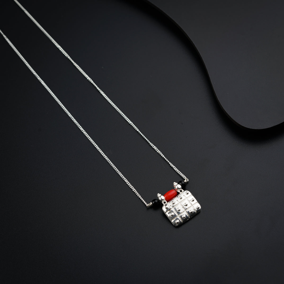 a red and white lego necklace on a black surface