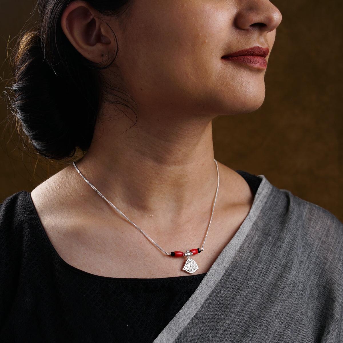 a woman wearing a necklace with a heart on it