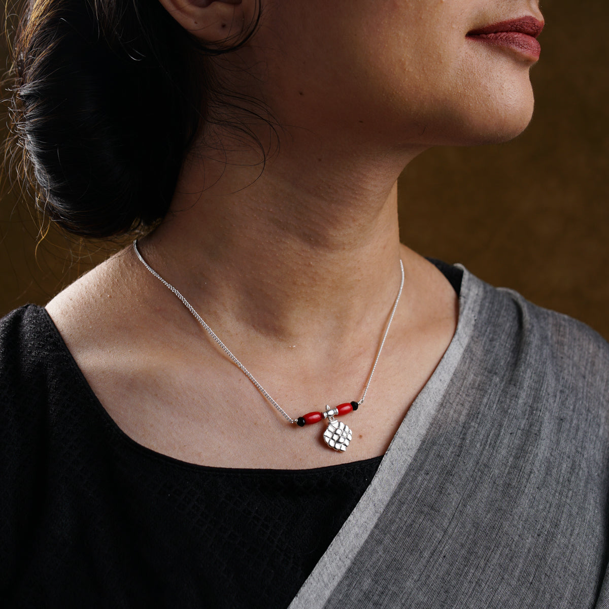 a woman wearing a red and white necklace