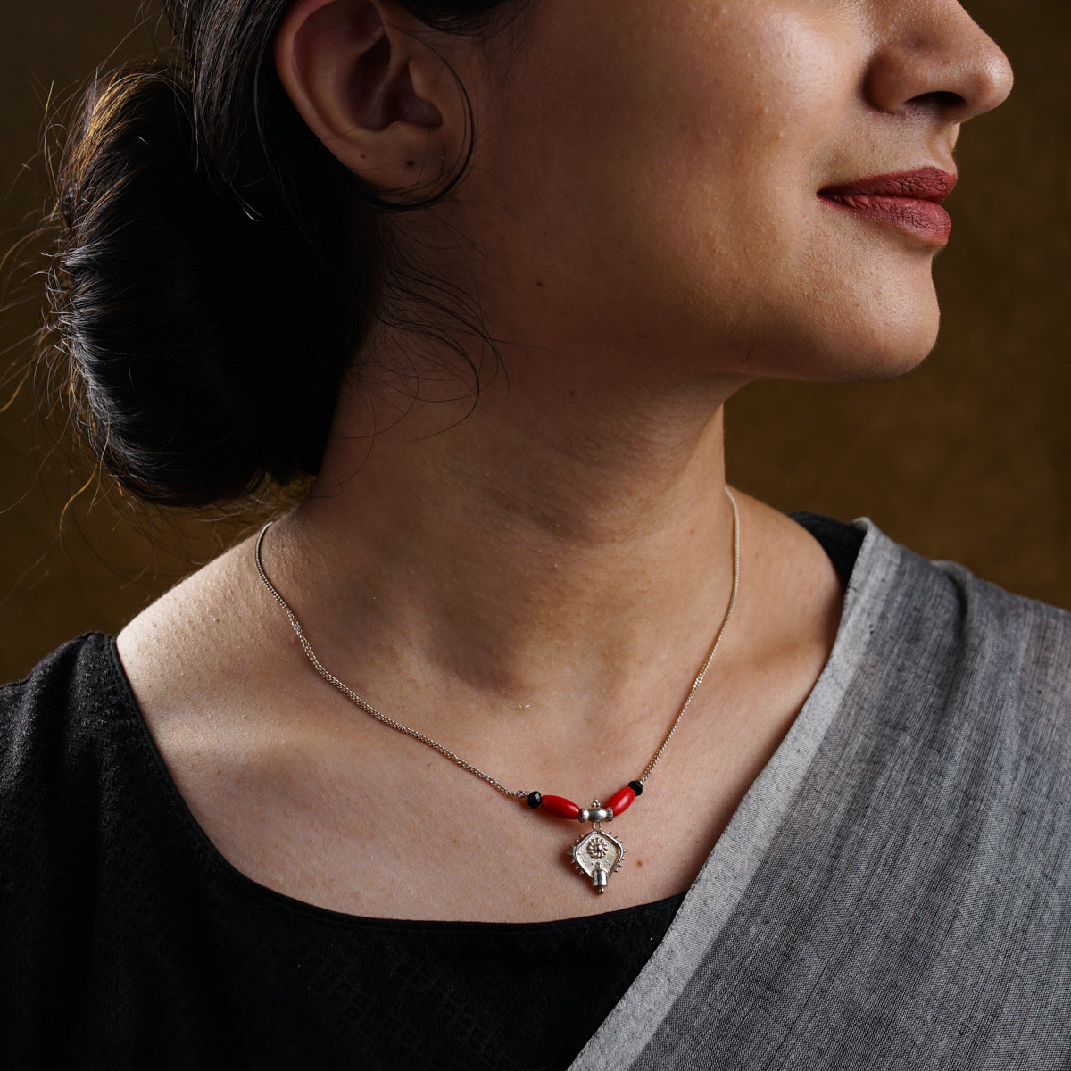 a woman wearing a necklace with a cross on it