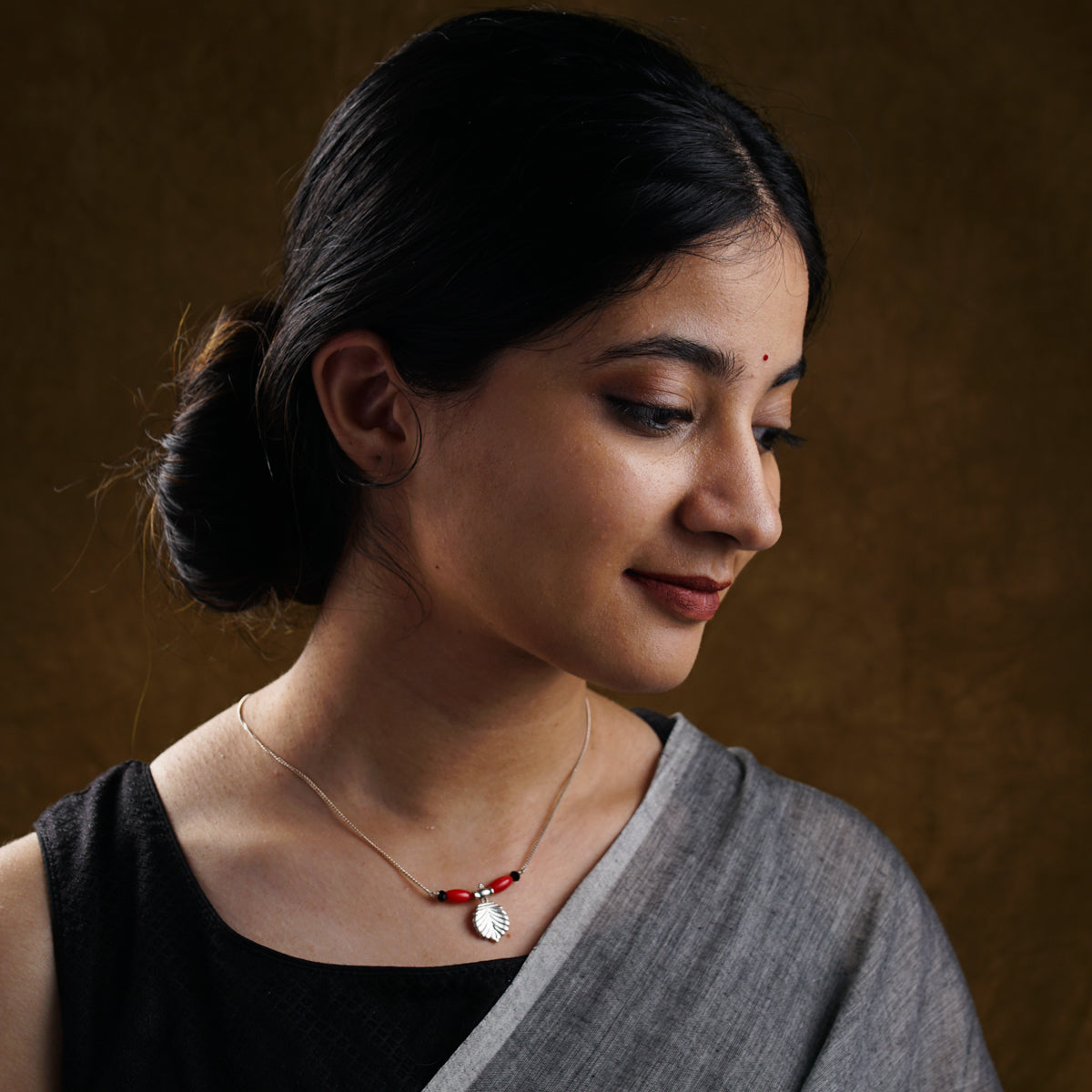 a woman wearing a necklace and a black top