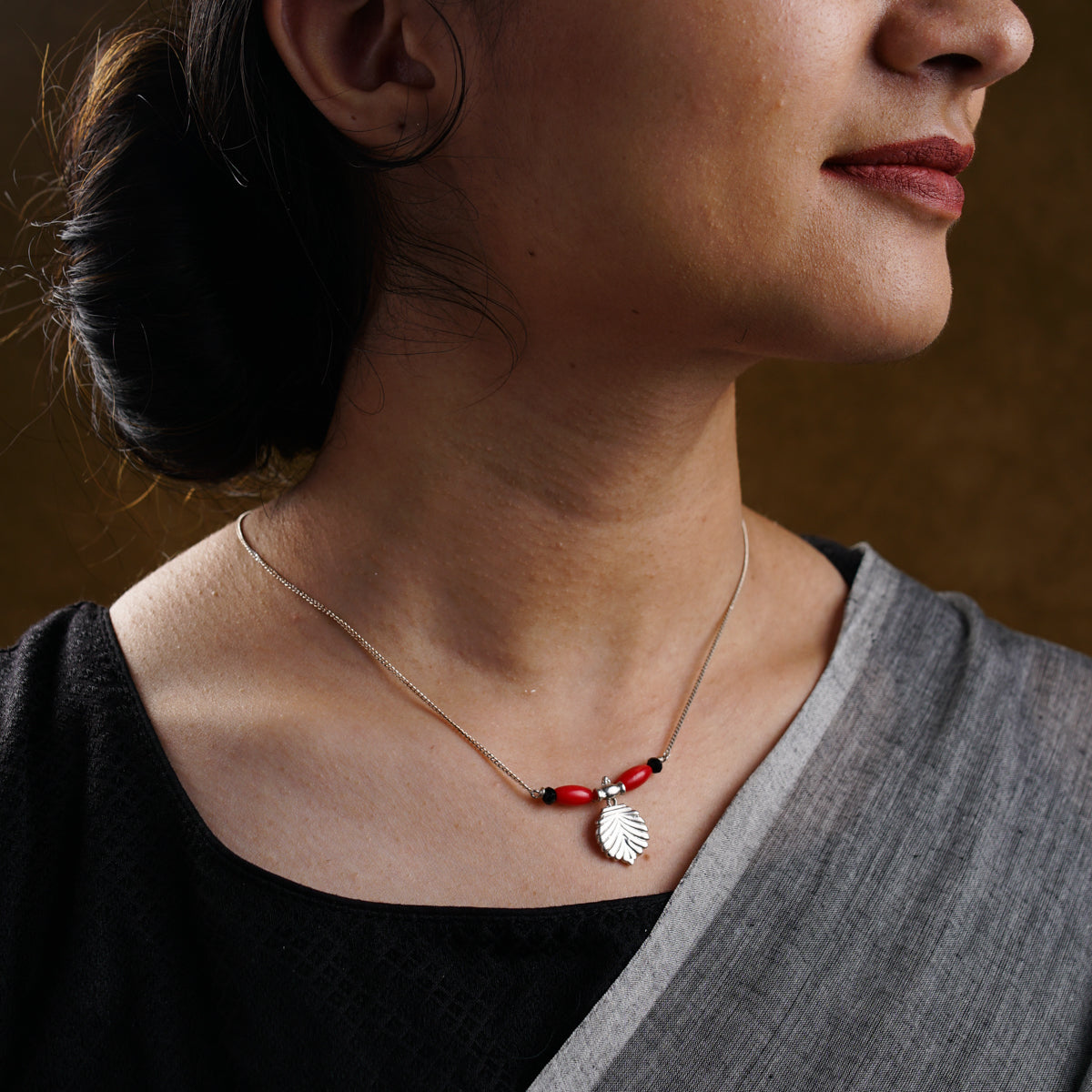 a woman wearing a red and white necklace