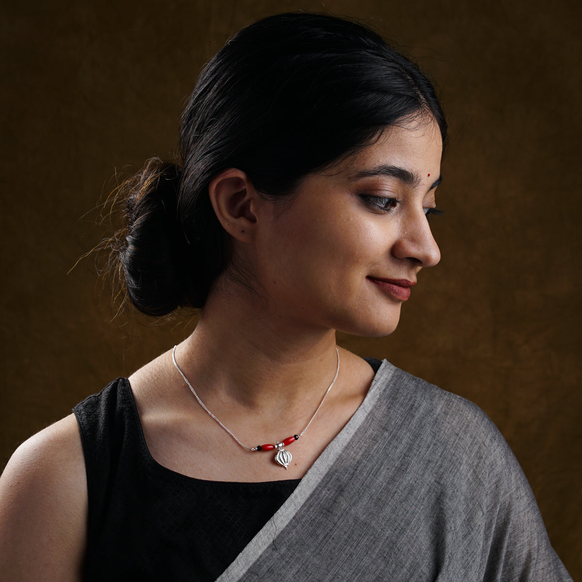 a woman wearing a necklace with a cross on it