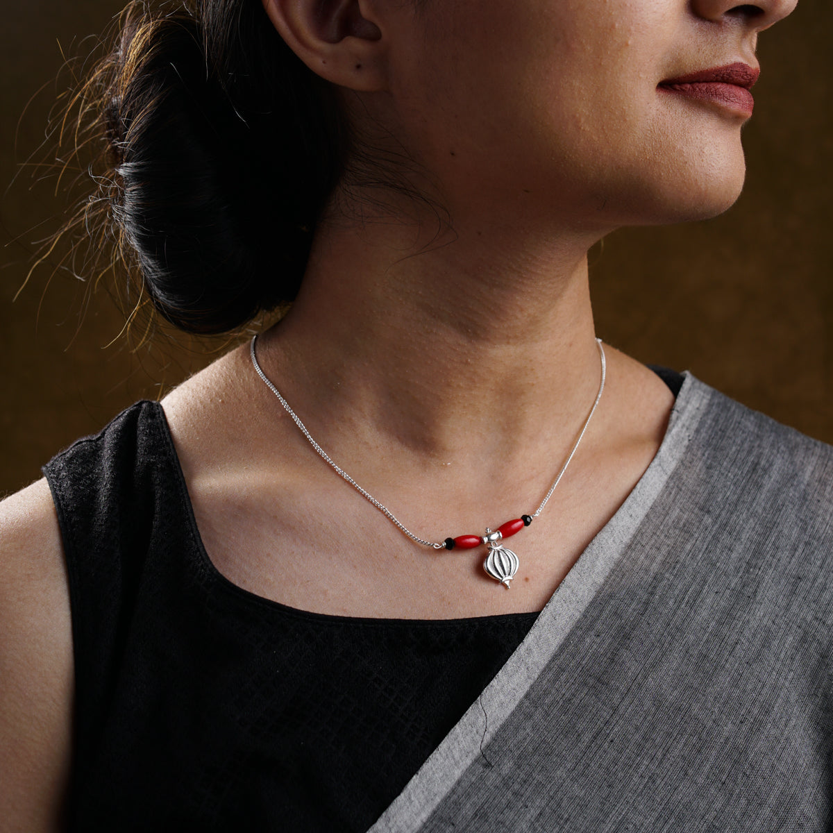 a woman wearing a red and white necklace