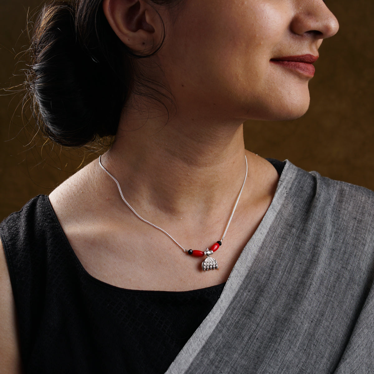 a woman wearing a necklace with a cross on it