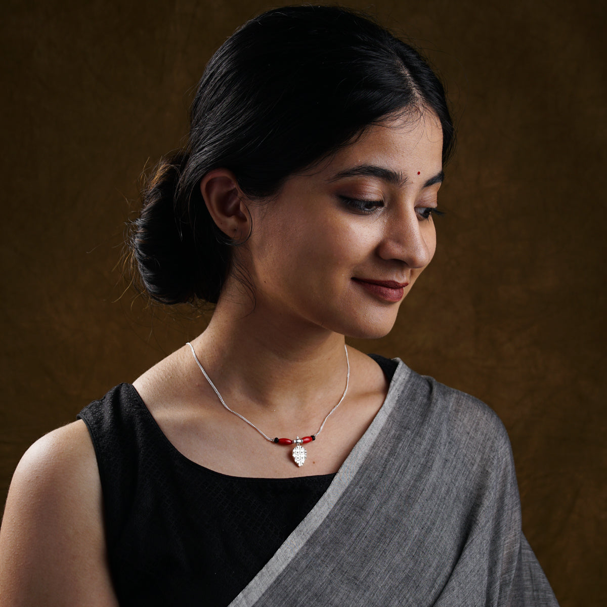 a woman wearing a necklace with a cross on it