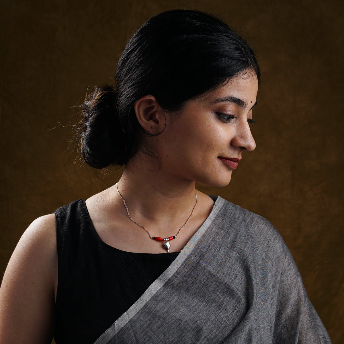 a woman wearing a necklace with a cross on it