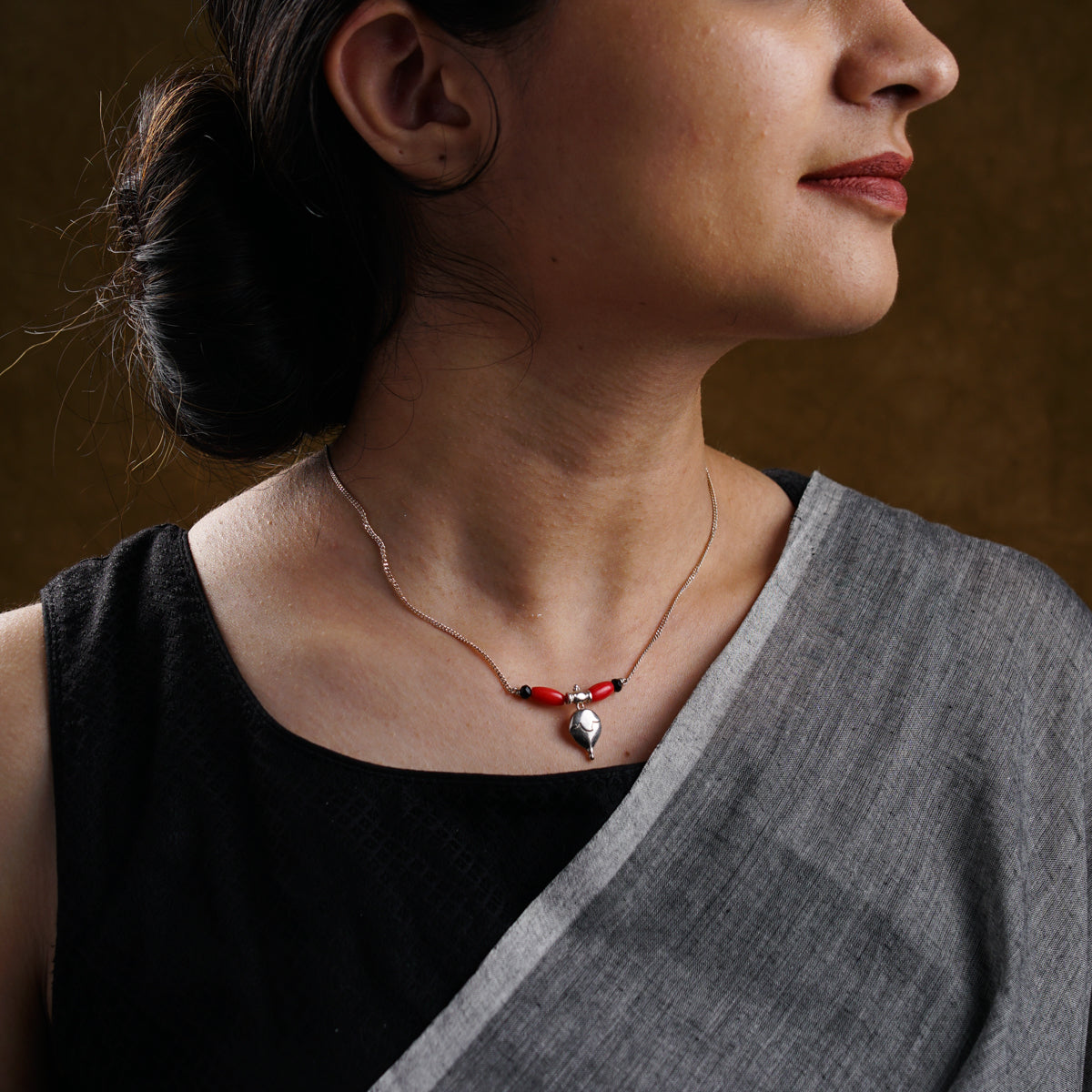 a woman wearing a necklace with a cross on it