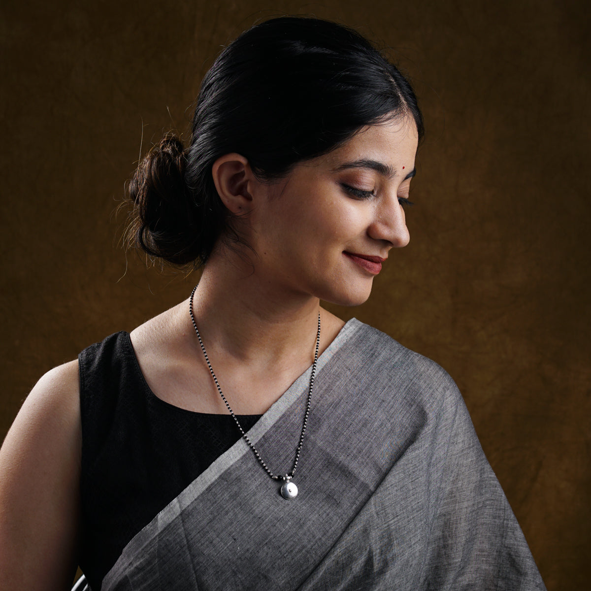 a woman in a black and white sari holding a cell phone