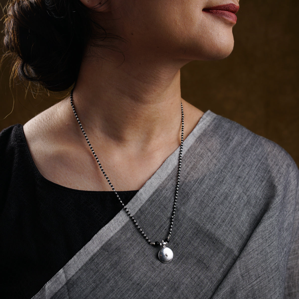 a woman wearing a black and white necklace