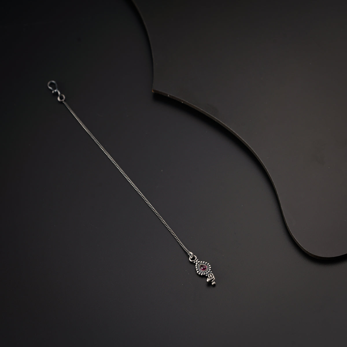 a silver necklace on a black background