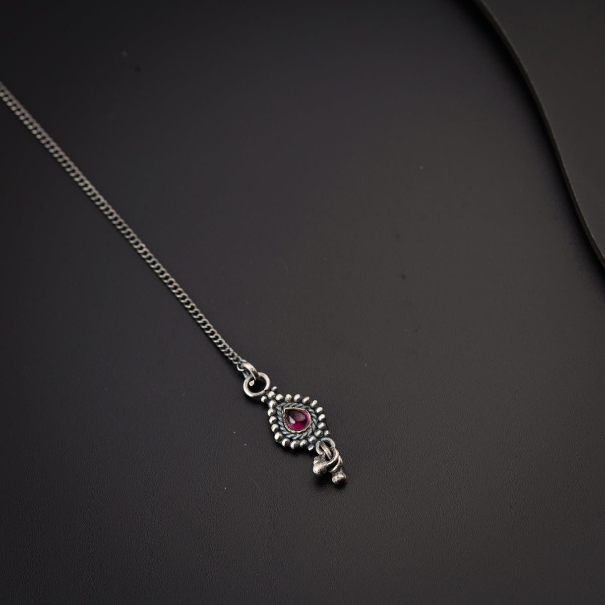 a close up of a necklace on a black surface