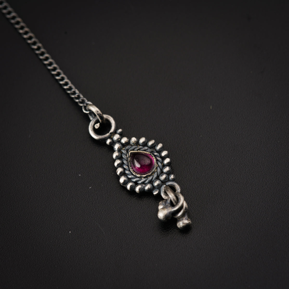 a close up of a necklace on a black surface