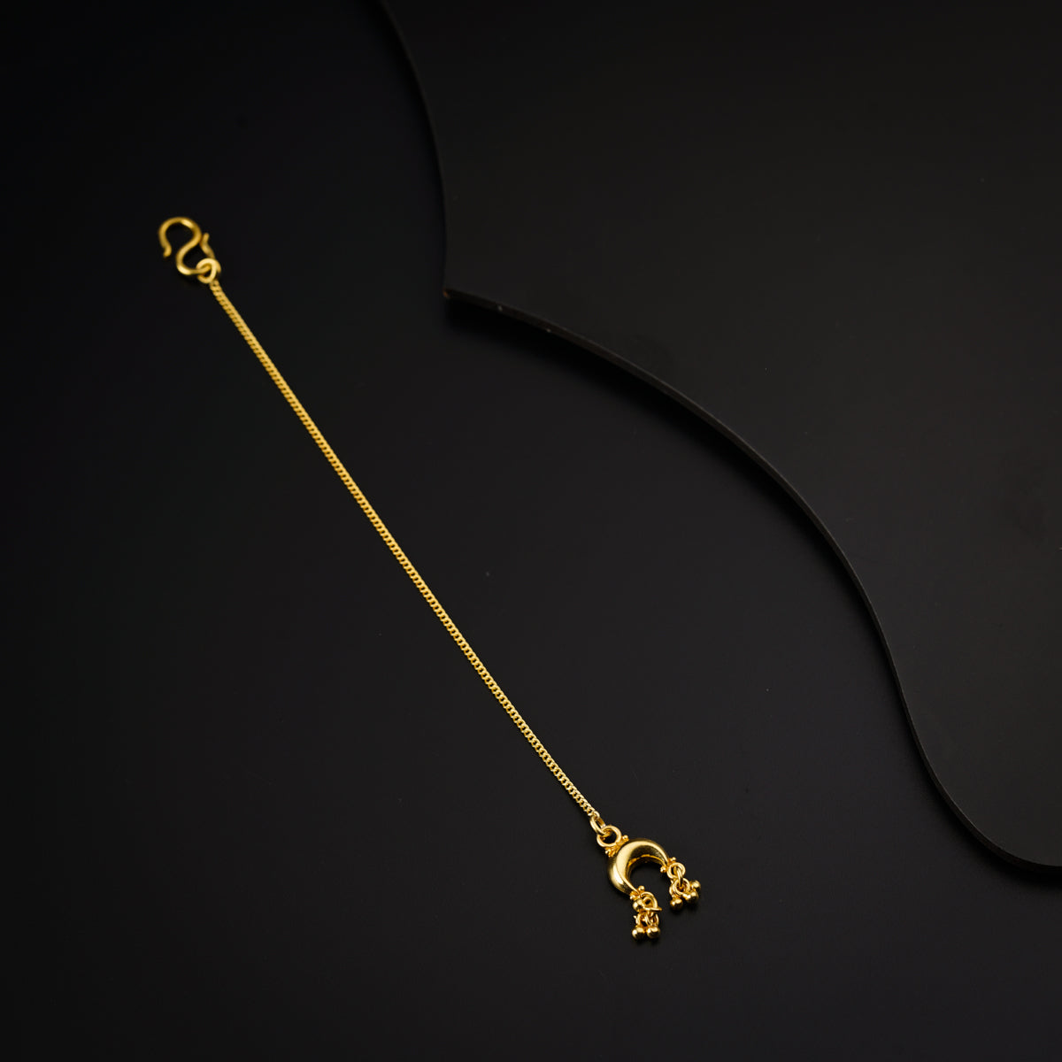 a gold necklace on a black background