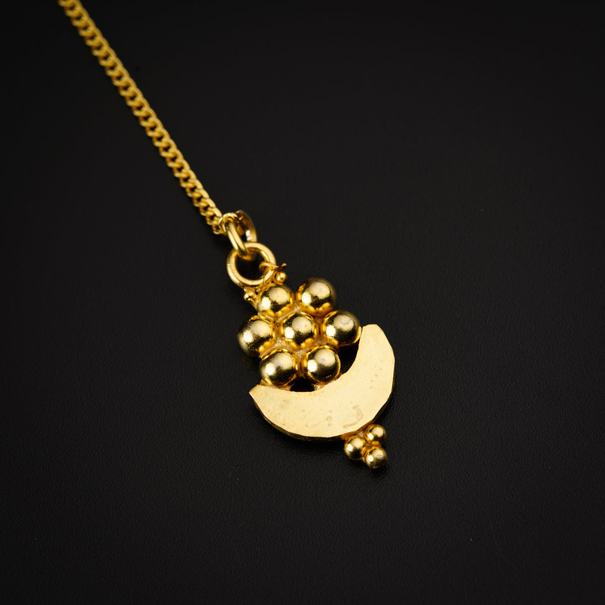 a gold necklace with beads hanging from it