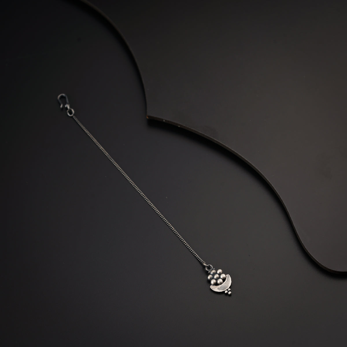 a necklace with a heart on a black background