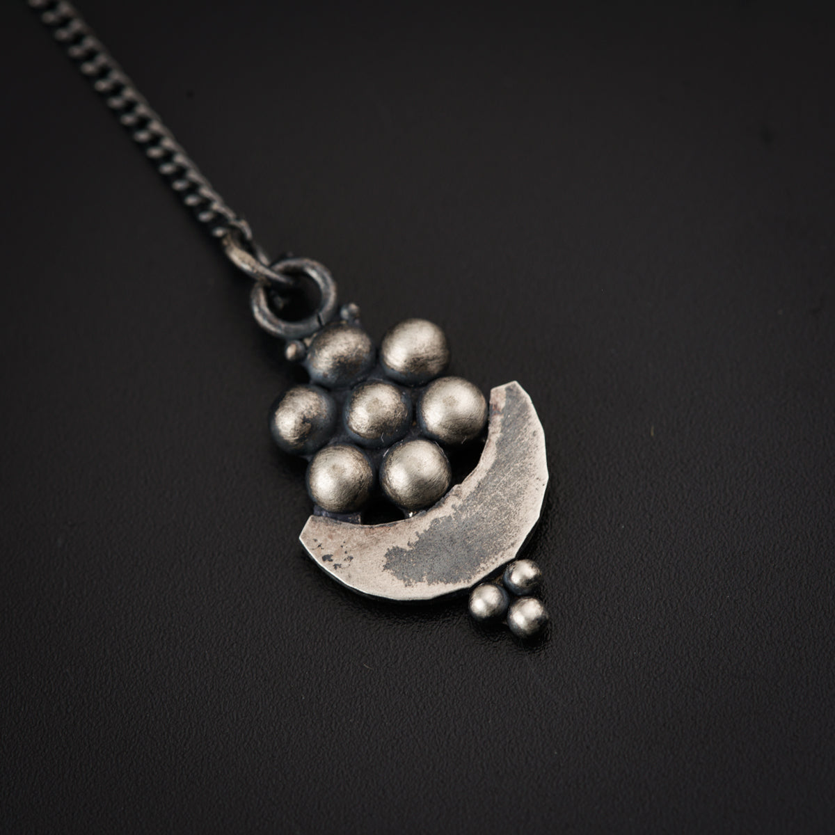 a silver necklace with balls hanging from it