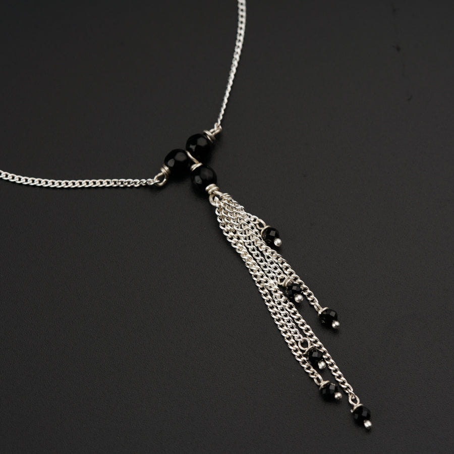 a black and silver necklace with a tassel
