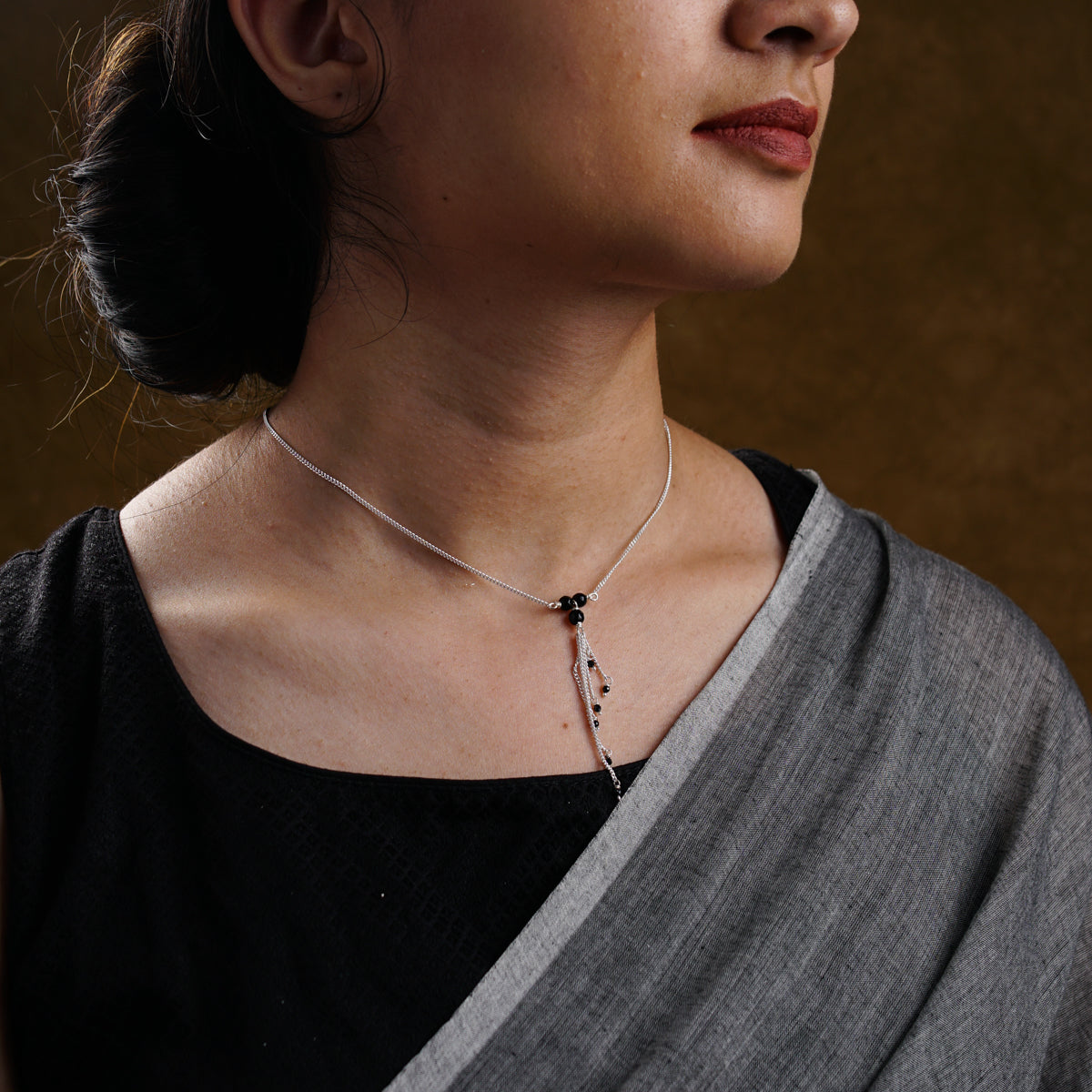 a woman wearing a necklace with a cross on it