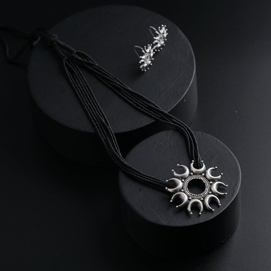 a pair of necklaces sitting on top of a black box