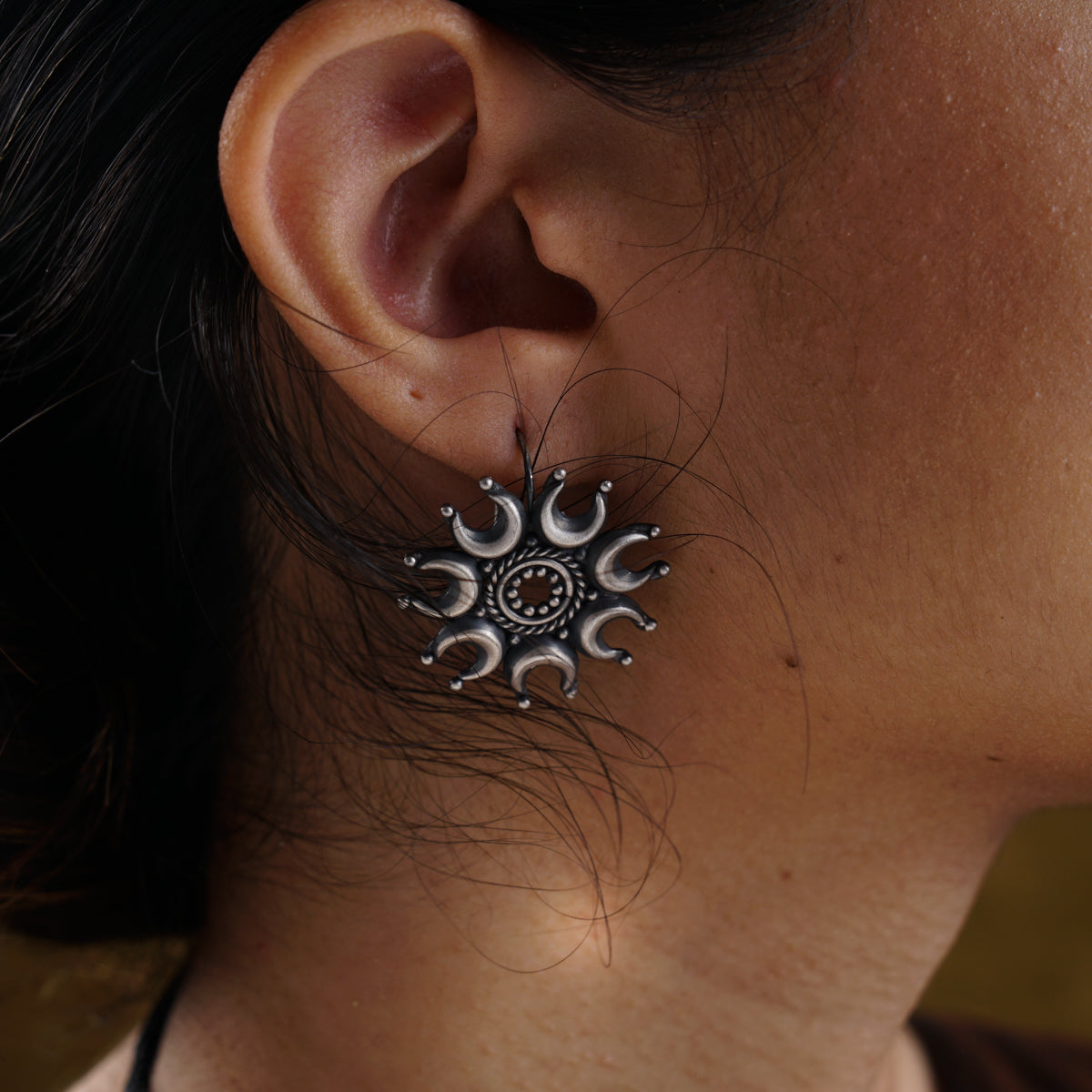 a close up of a person wearing a pair of earrings