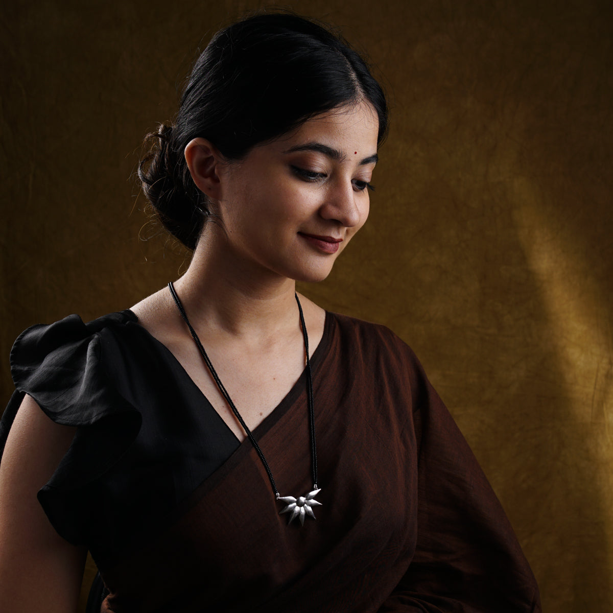 a woman in a brown dress holding a cell phone