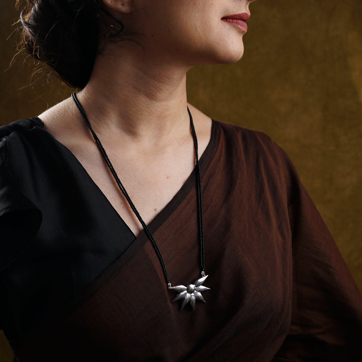 a woman wearing a necklace with a star on it