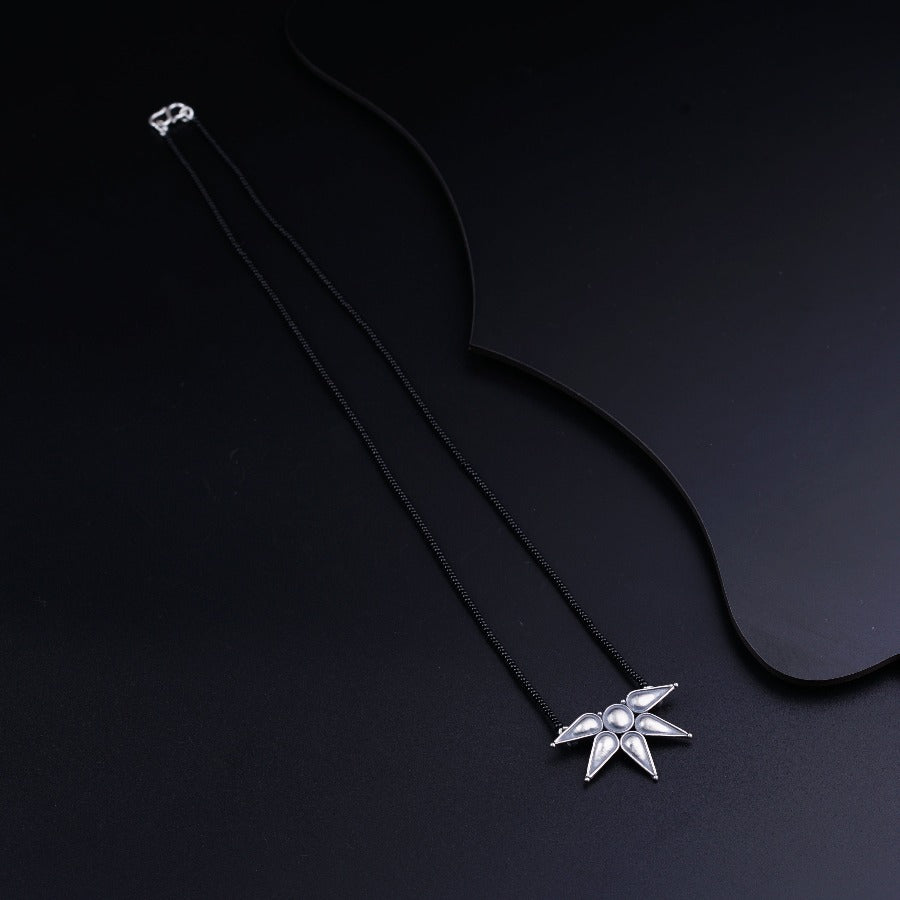 a necklace with a star on a black background