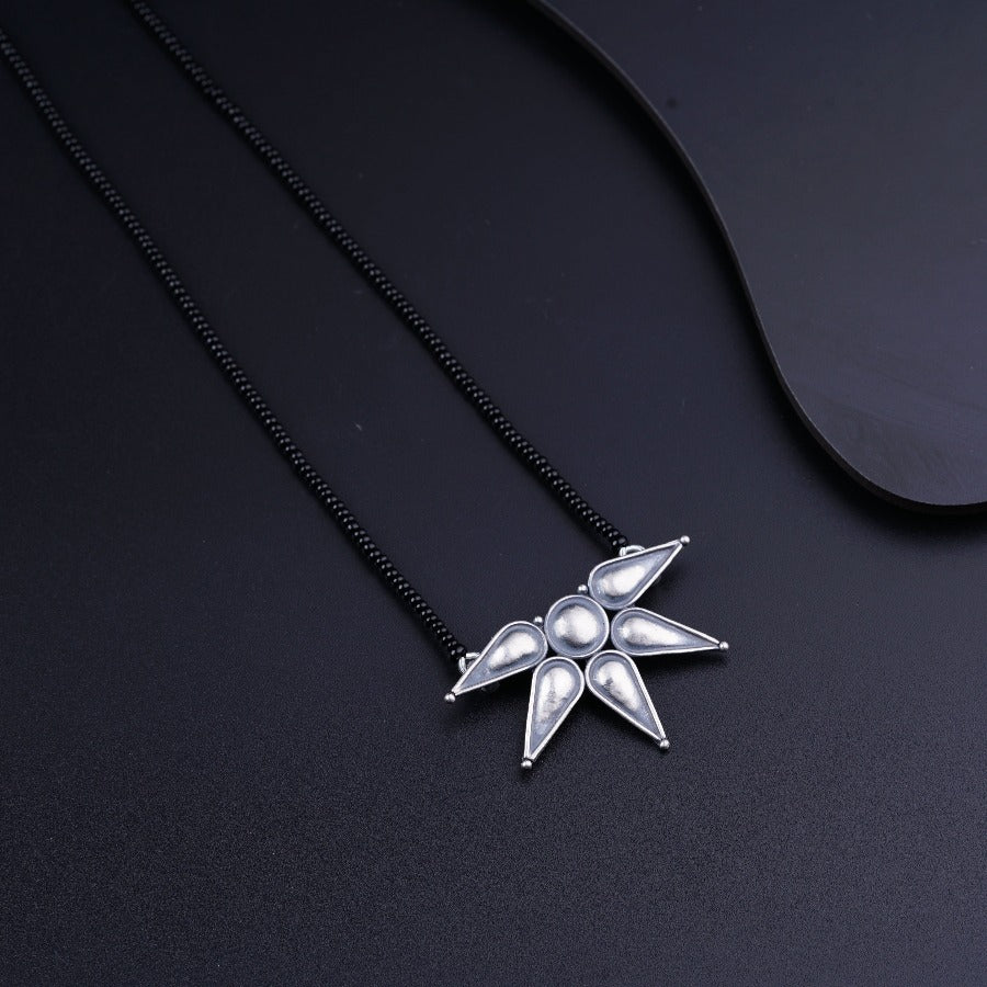 a silver necklace with a star design on it