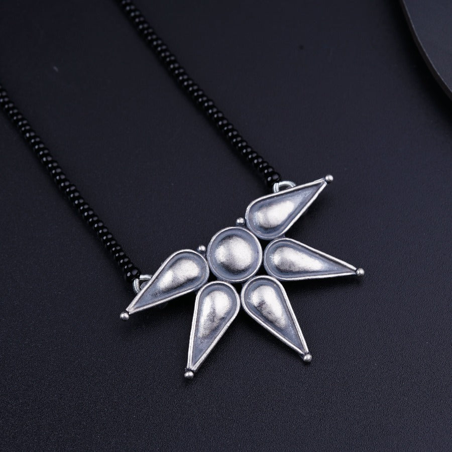 a silver necklace with a star design on it