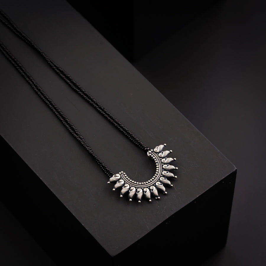 a pair of necklaces sitting on top of a black box