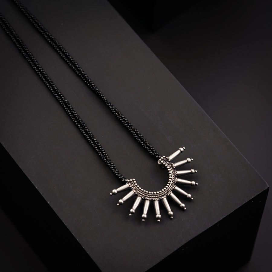 a necklace with spikes on a black surface