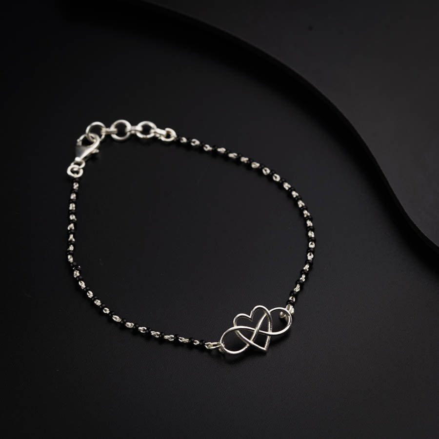 a bracelet with two hearts on a black surface